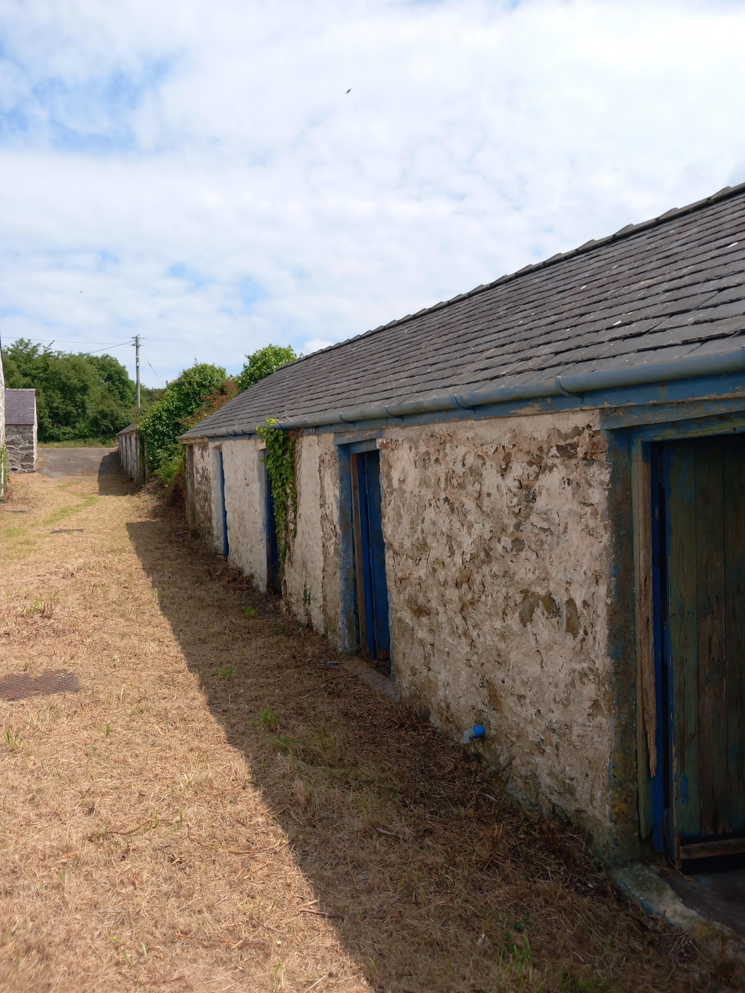 The row of sheds opposite the Penmynydd Almshouses - they were added in the 19th century and were used for storage and as wash houses Image Dale Spridgeon
